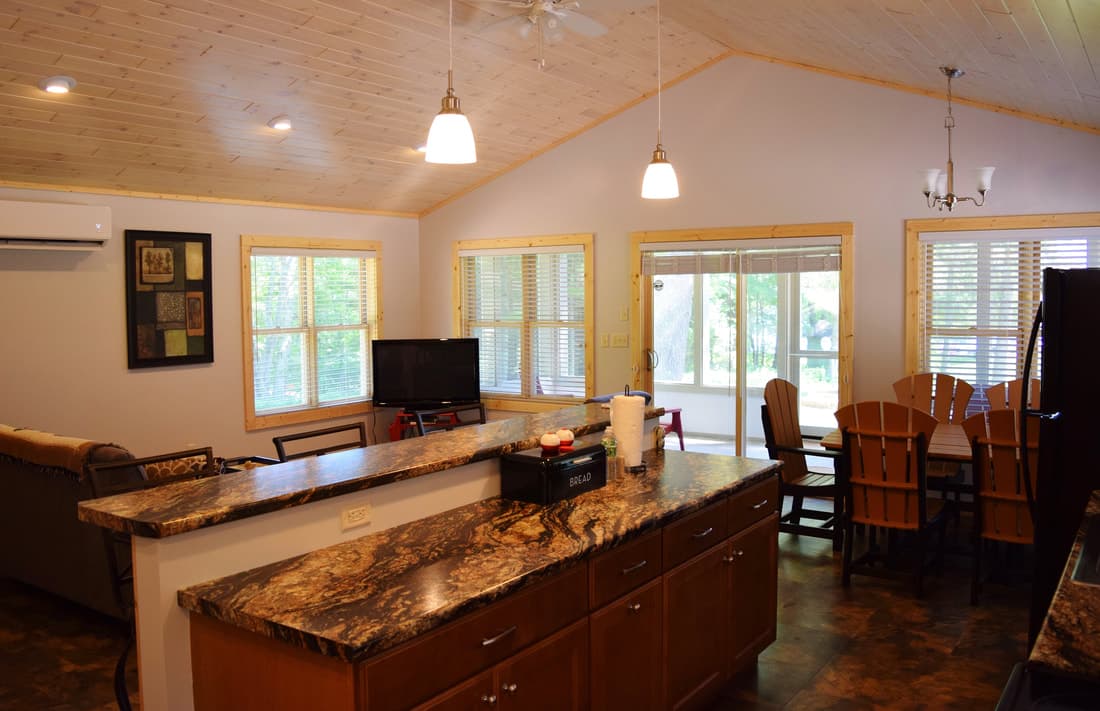 Kitchen island and living area under the pine ceiling of the Red Cabin